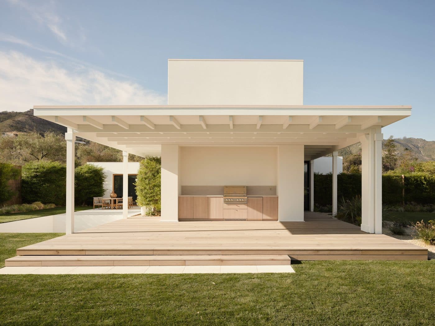 Single-story addition with a covered patio opening onto a lawn