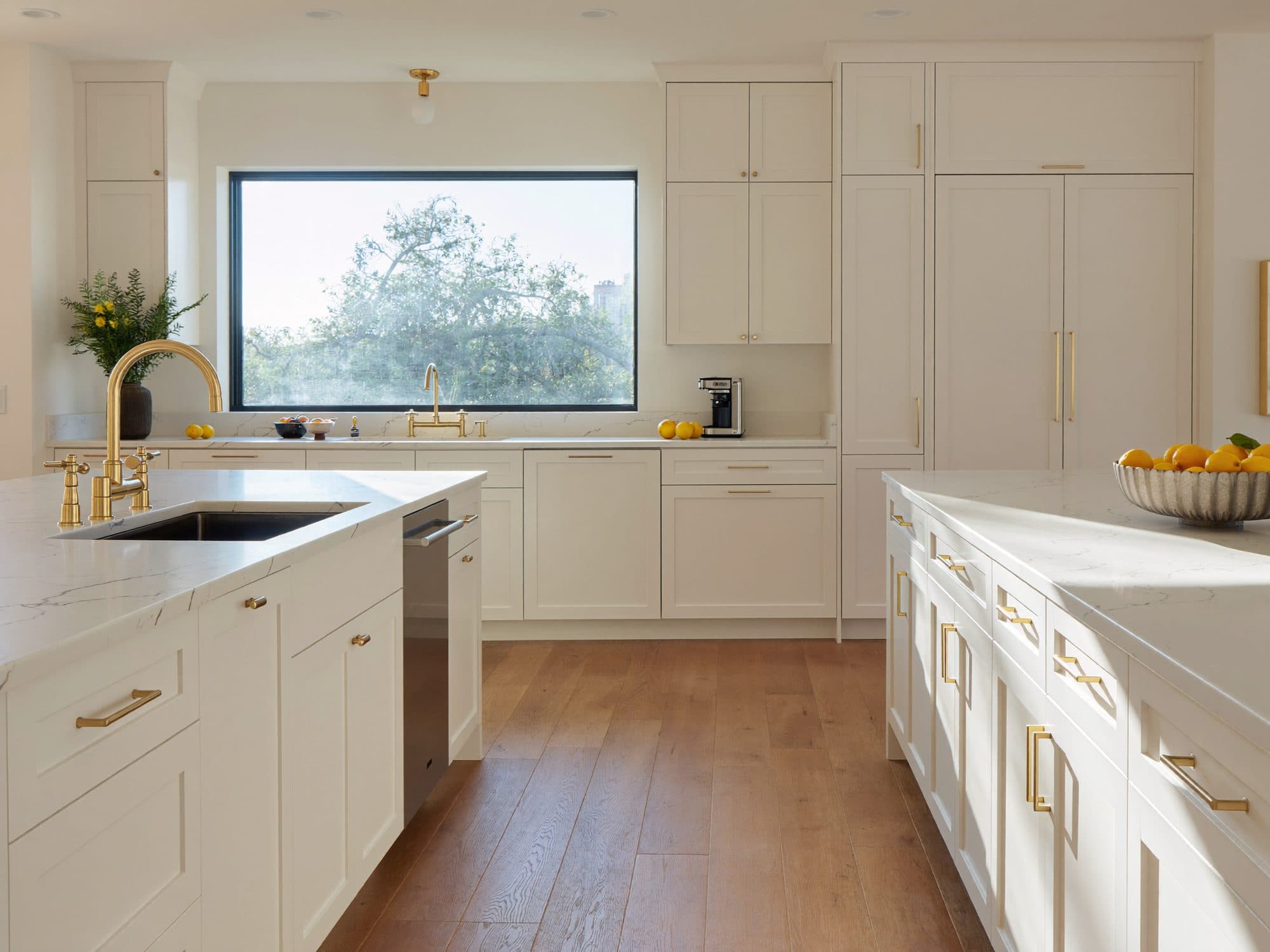 Bright remodeled kitchen with white cabinets and oak floors